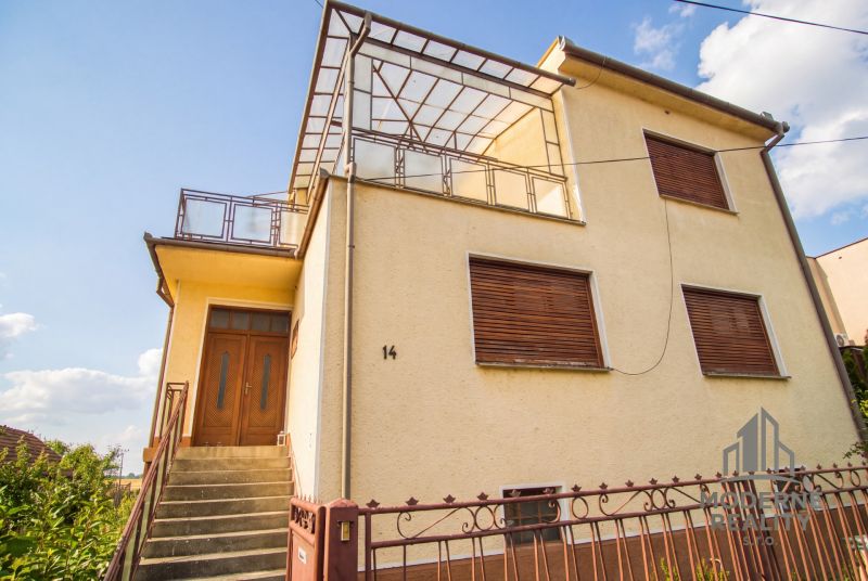 A family house in Dvory nad Žitavou with wooden shutters and a spacious terrace.