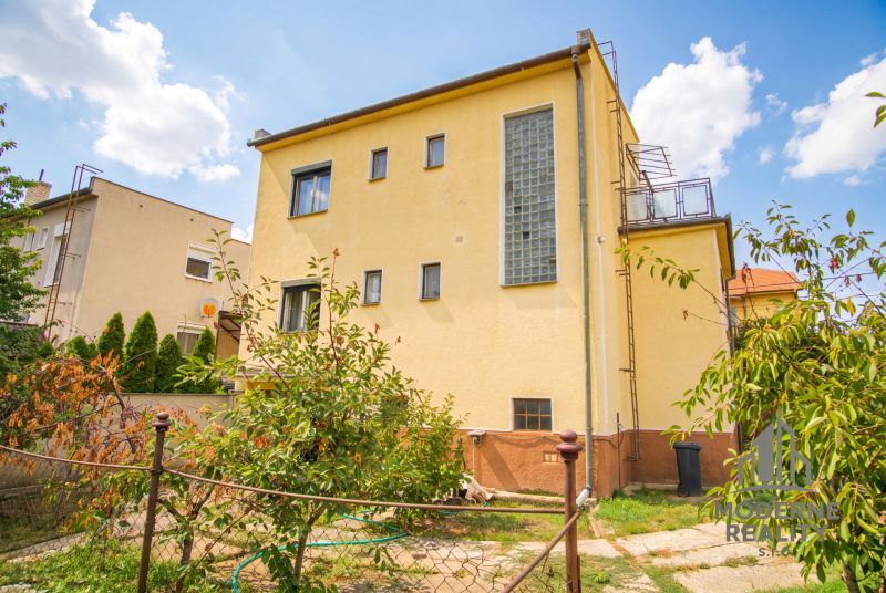 A family house in Dvory nad Žitavou with large windows and a landscaped garden.