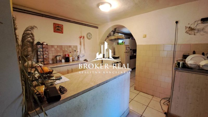 Rustic kitchen with tiled walls and a counter in the cottage.