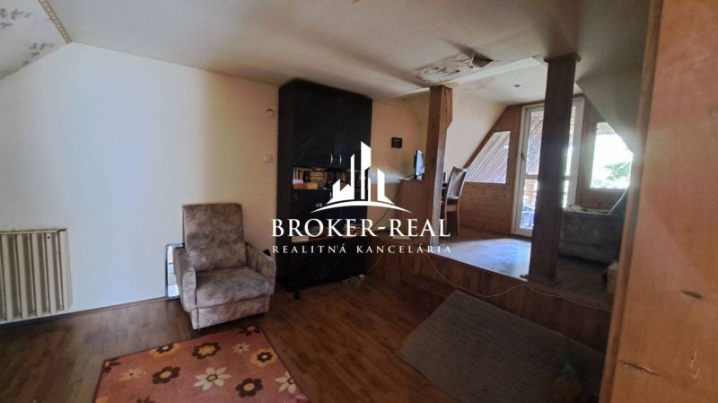 Attic interior of a cottage with an armchair and a wooden decor floor.