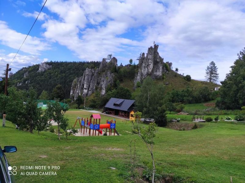 Recreational plots in Turany with a playground and rock formations on a green meadow.