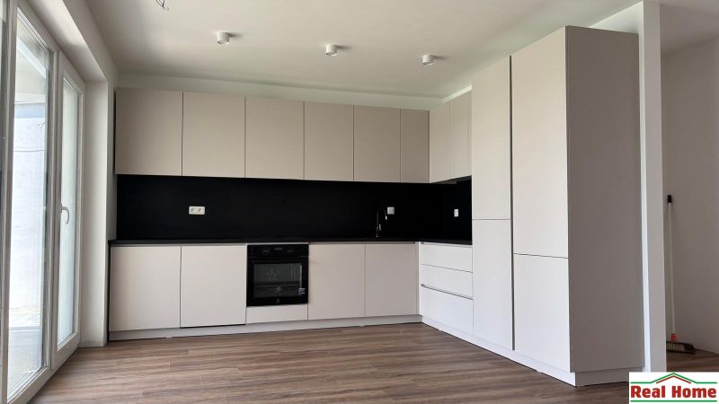 A kitchen in a family house with white cabinets and a wood-patterned floor.