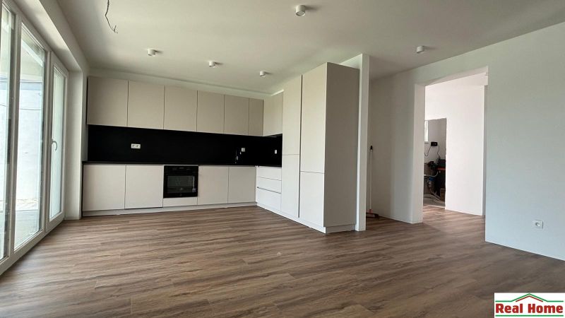 A spacious kitchen with a wooden decor floor in a family house.