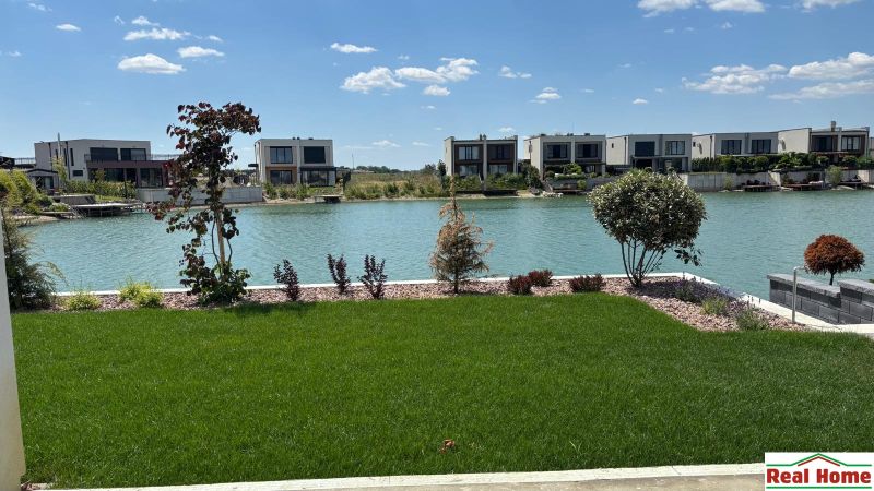 A family house in Boldog with a garden by the lake and a green lawn.