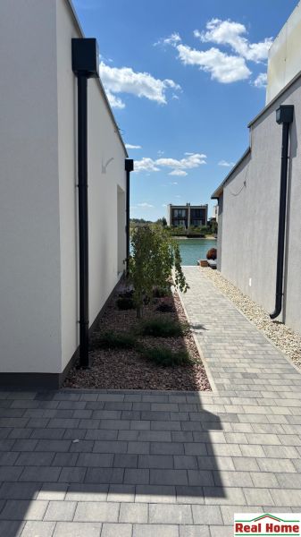 A narrow path between two family houses in Boldog leads to the lake at the end.