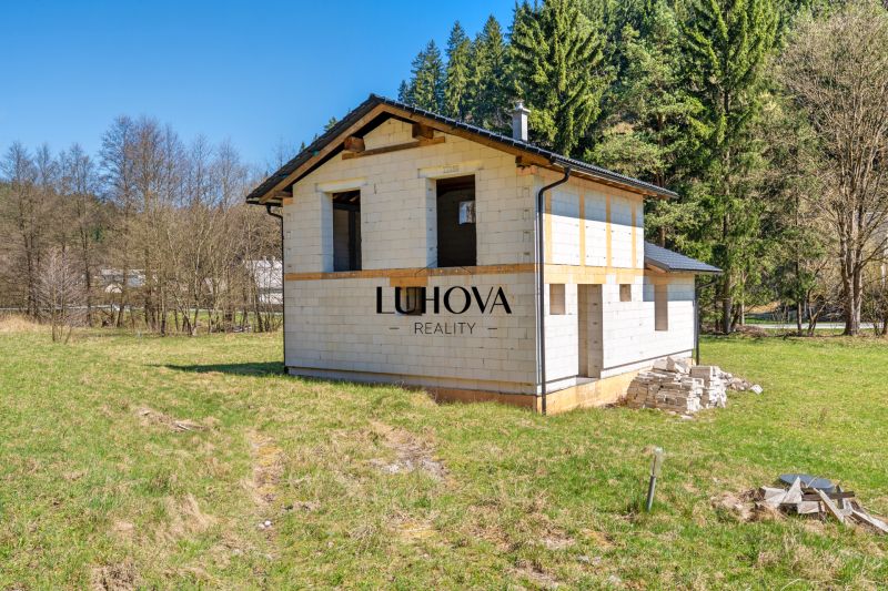 The exterior of a family house in Lazy pod Makytou surrounded by nature and a grassy area.