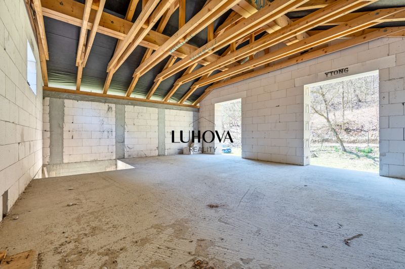 The interior of a family house with a wooden ceiling and large open spaces.