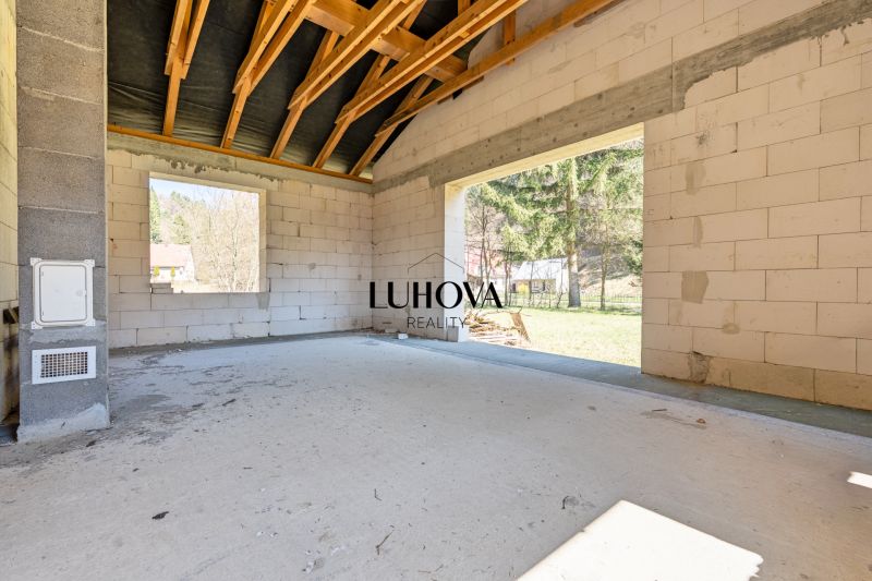 The interior of a family house with unfinished walls and a view of the garden.
