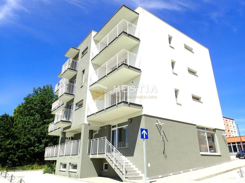 A four-story apartment building in Senica with balconies and a staircase, offering three-bedroom apartments.