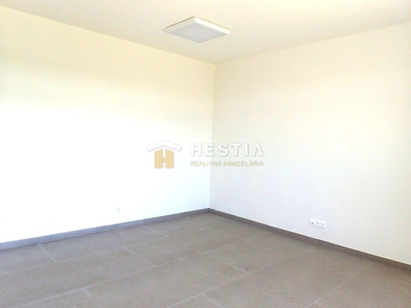 Empty room with neutral walls and large tiles on the floor, suitable for commercial properties.