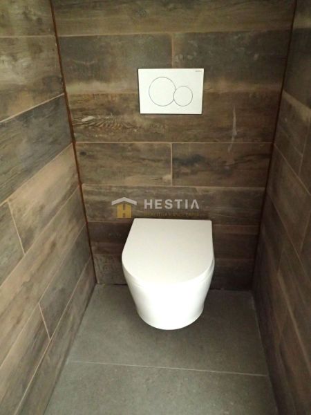 Bathroom with toilet and walls with wooden decor. Plots - commercial.