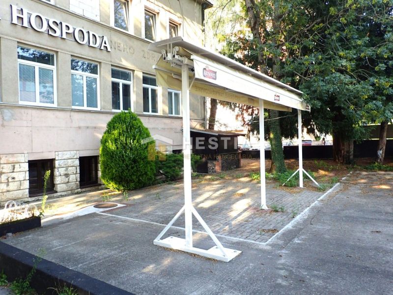 Commercial premises in Senica with parking, greenery, and a sign on the building.