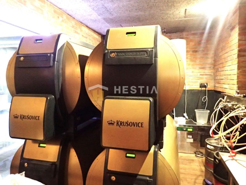 Beer kegs in commercial spaces with brick cladding and cables on a wooden-decor floor.
