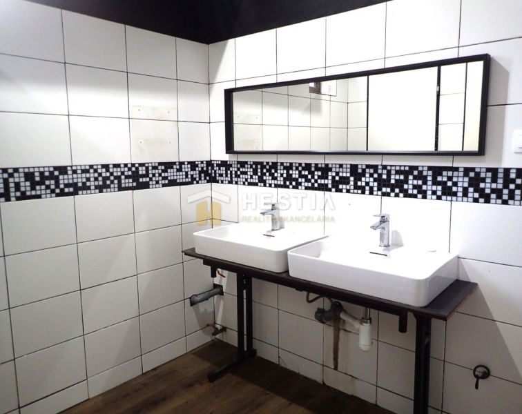 Sinks in pairs with white tiles and a wooden decor floor in commercial spaces.