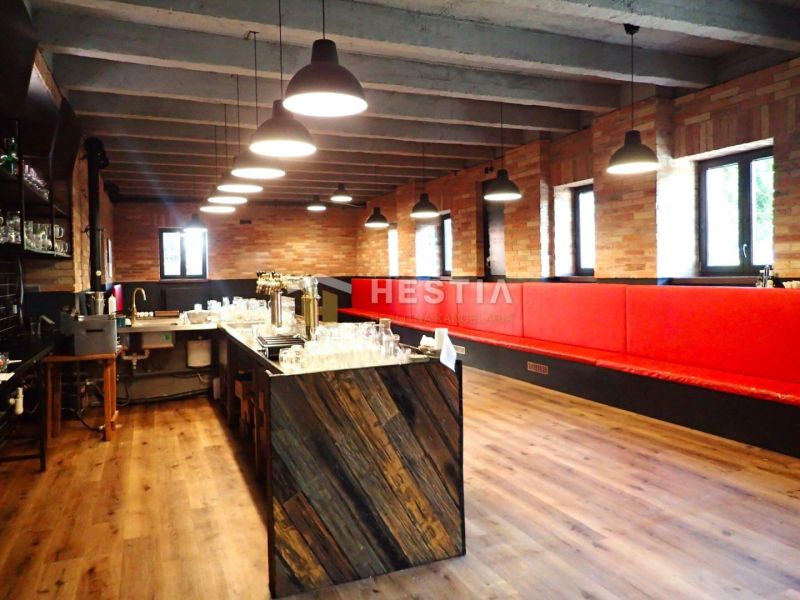 Commercial space with wood-patterned flooring, red seating, and industrial lighting.