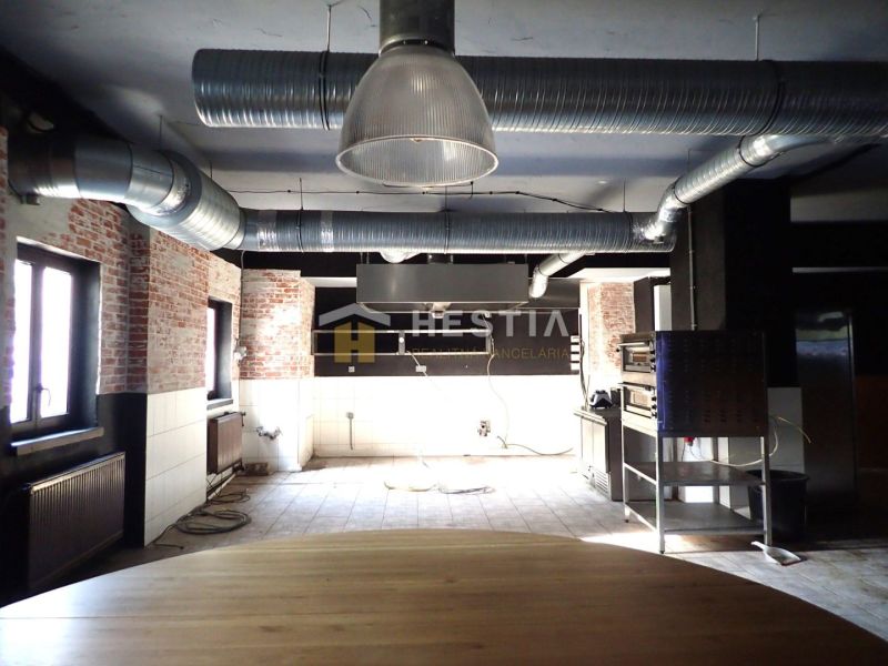 Interior of commercial spaces with visible brick wall and HVAC on the ceiling.