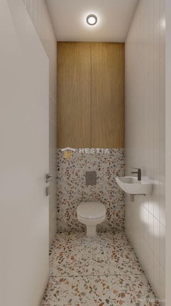 A toilet in a family house with a sink and terrazzo tiles.