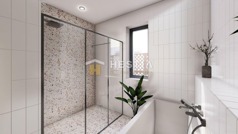 Shower corner with terrazzo tiles and white tiles in the bathroom of a family house.