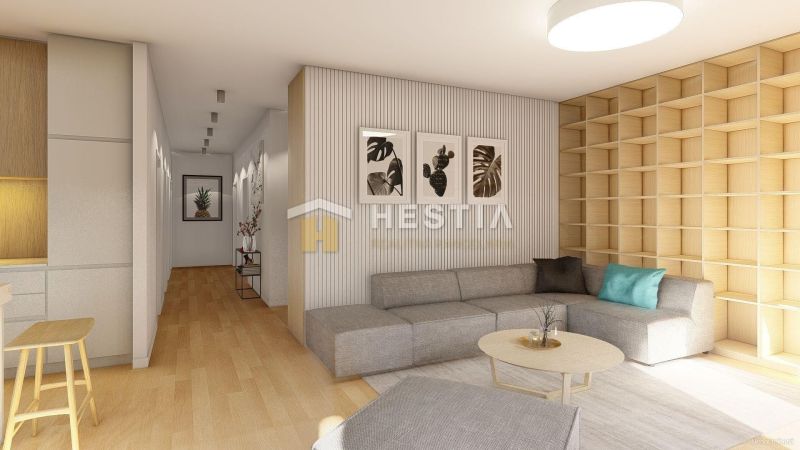 Living room of a family house with a grey sofa, wood-patterned flooring, and wooden shelves.