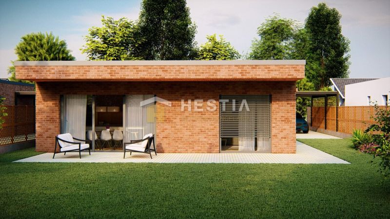 A family house in Hlboké with brick cladding, a terrace, and a green lawn.