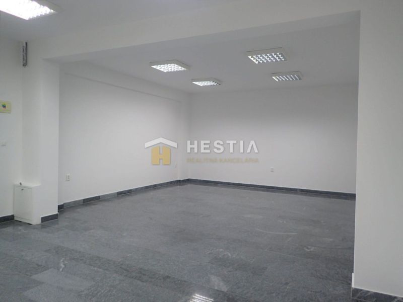 White room with tiling and built-in lighting, intended for commercial use.