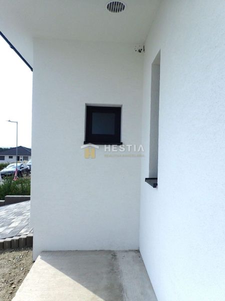 A family house in Hlboké with a white facade and a small window by the entrance.