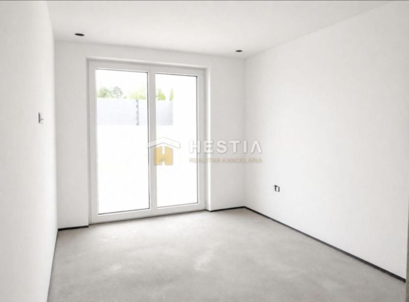 The interior of a family house with white walls and large balcony doors.