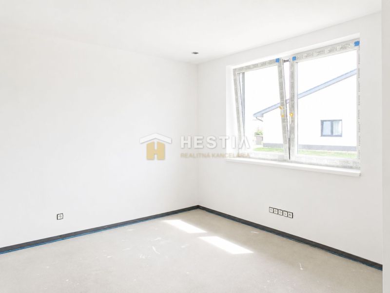 Bright room in a family house with large windows and white walls.