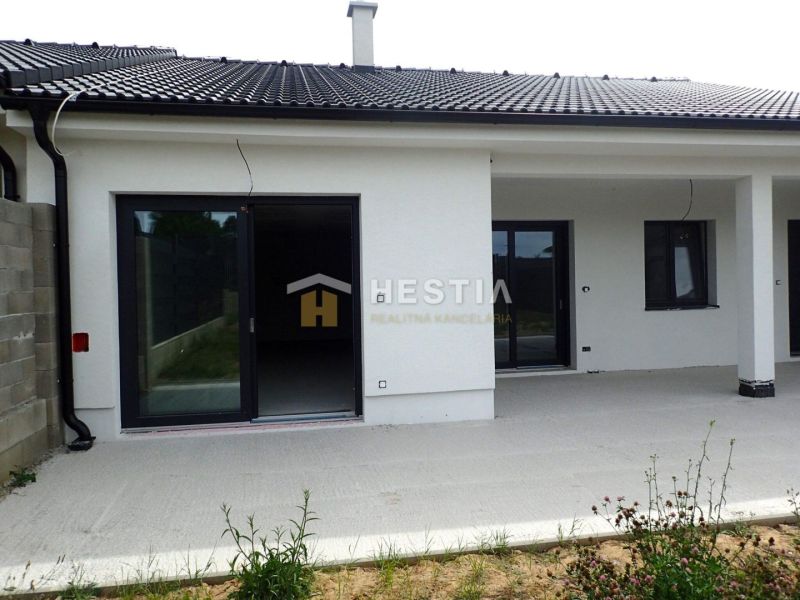 A family house in Hlboké with a concrete terrace and a black roof.