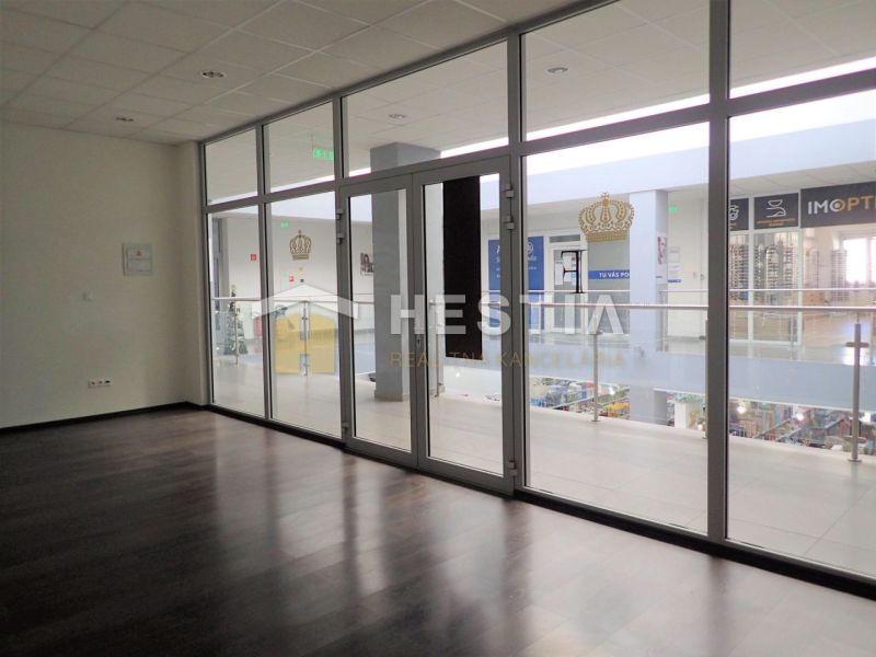 A glazed interior of a 2-room apartment with a wooden decor floor and a view into the hallway.