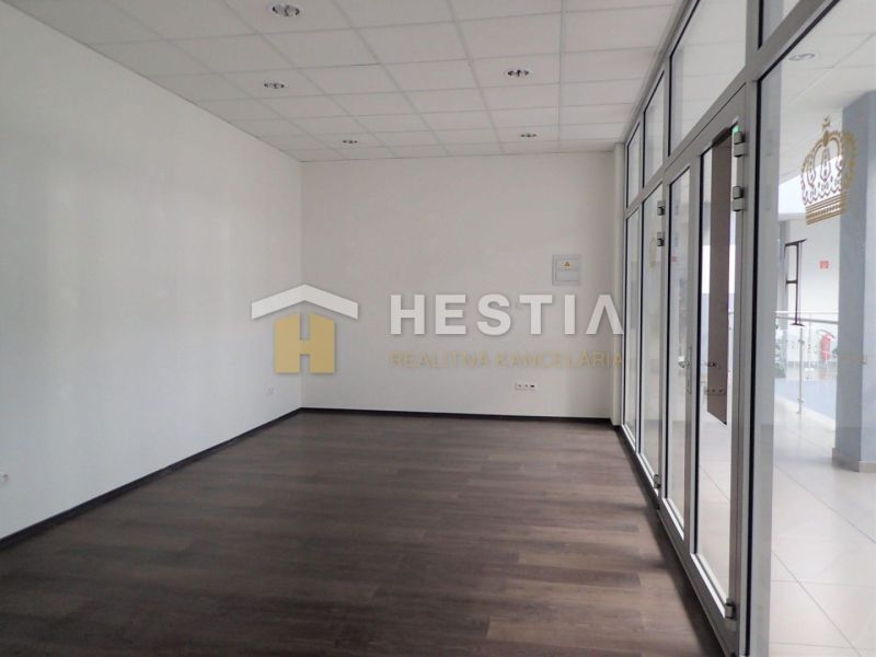 A spacious room with glass doors and a wooden decor floor in a 2-room apartment.
