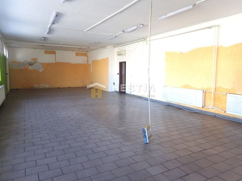 A spacious room with a tiled floor, light-colored walls, and lighting in a family house.