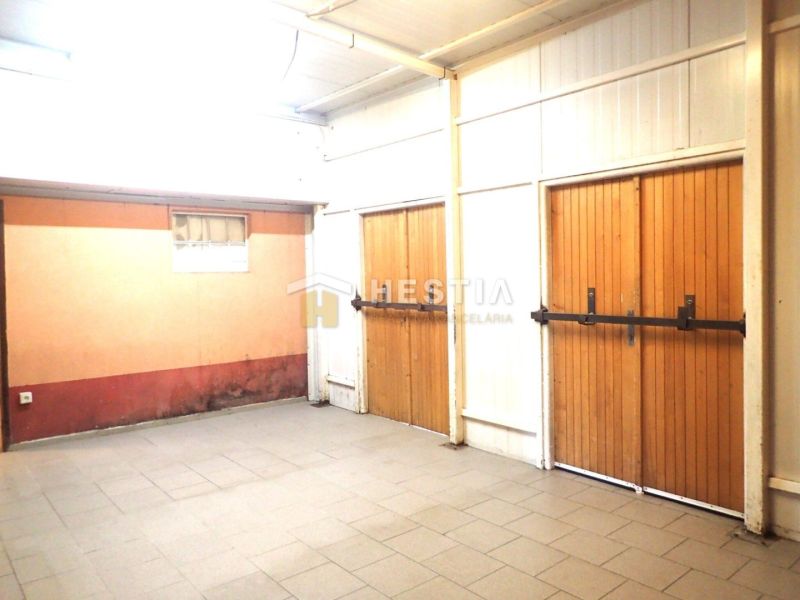 A garage in a family house with large wooden gates and ceramic tiles.