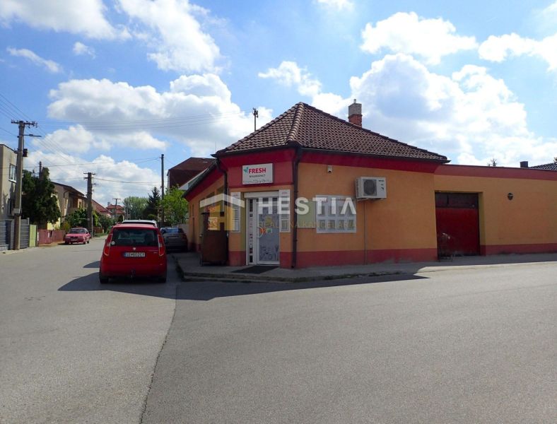 A family house in Borský Mikuláš with a shop, a car, and a clear sky.