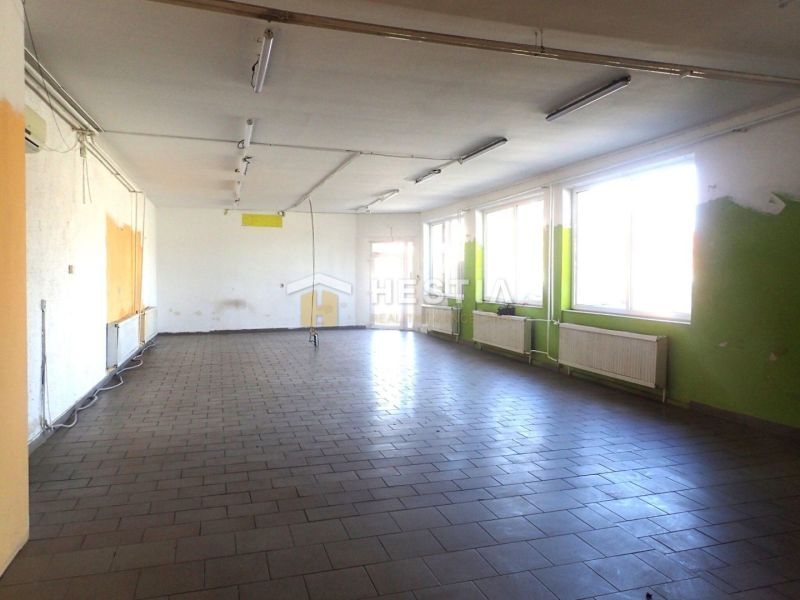 A spacious room in a family house with tiled flooring and large windows.