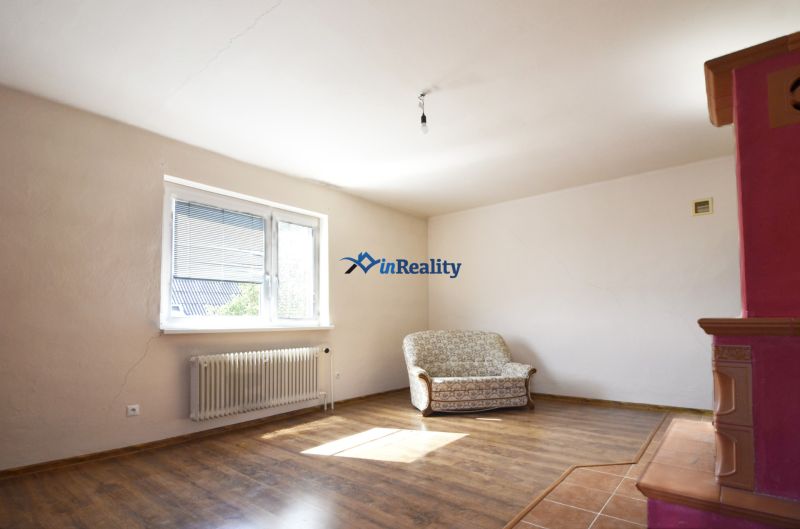 Living room in a family house with a wooden decor floor and a two-seater sofa.