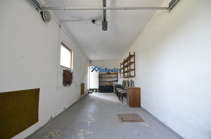 A garage with white walls and storage space in a family house.