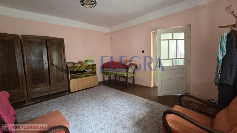 A room in a family house with furniture and pink walls.