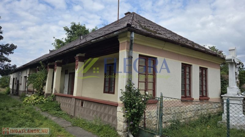 A family house in Boldogkőújfalu with traditional architecture and a stone fence.