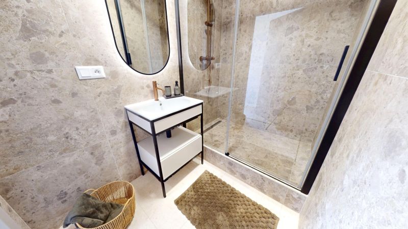 Bathroom with a shower, mirror, and modern sink in a 3-room apartment.