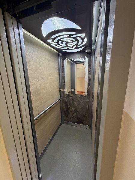 An elevator with modern lighting and wooden wall decor.