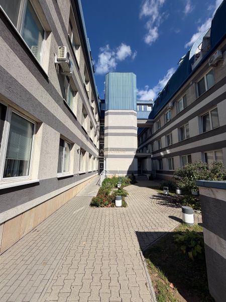 The building on Bajkalská Street in Bratislava-Ružinov with a landscaped courtyard and clear sky.