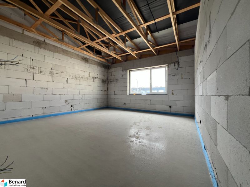 Newly constructed commercial spaces with a concrete floor and a large window in Lipany.