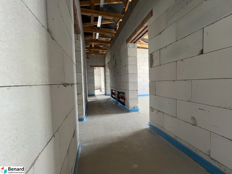 A part of commercial premises with concrete walls and an unfinished roof.