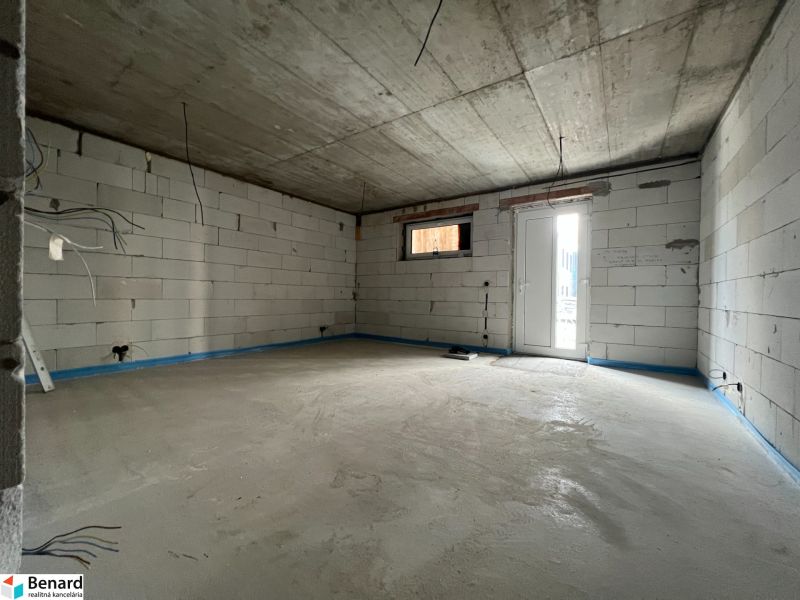 Empty commercial spaces with concrete floors and white bricks.