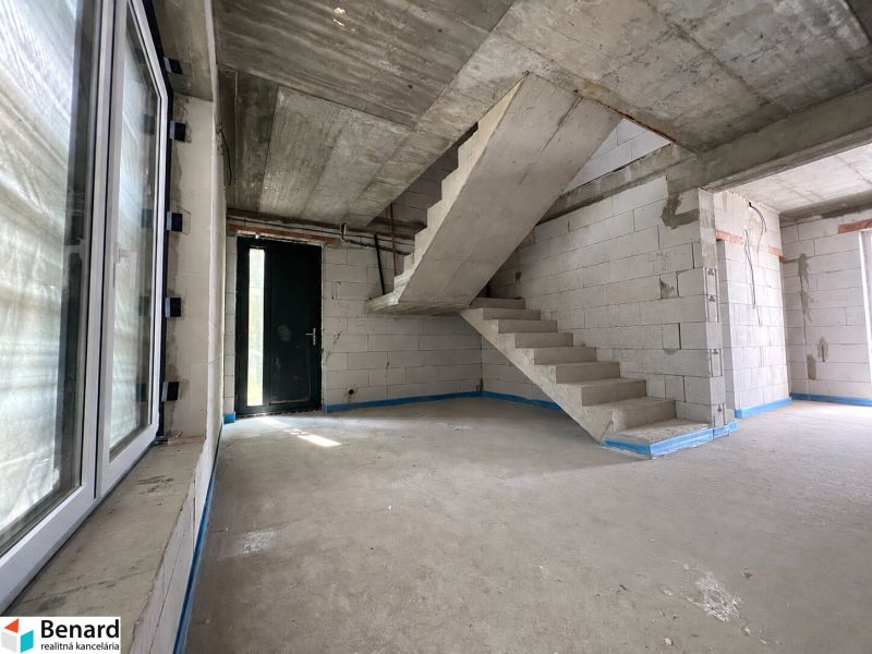 Concrete staircase in commercial premises with light entering through the window and door.