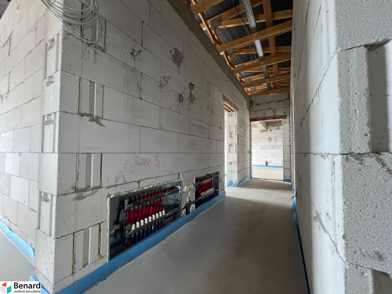 Interior of commercial spaces with a plain concrete floor and wiring on the wall.