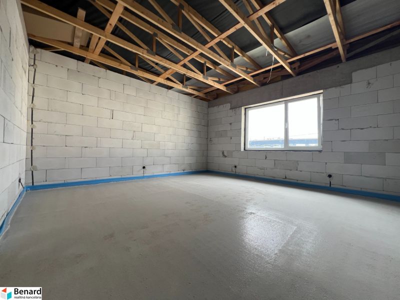 Interior of commercial premises with unfinished walls and a wooden ceiling.