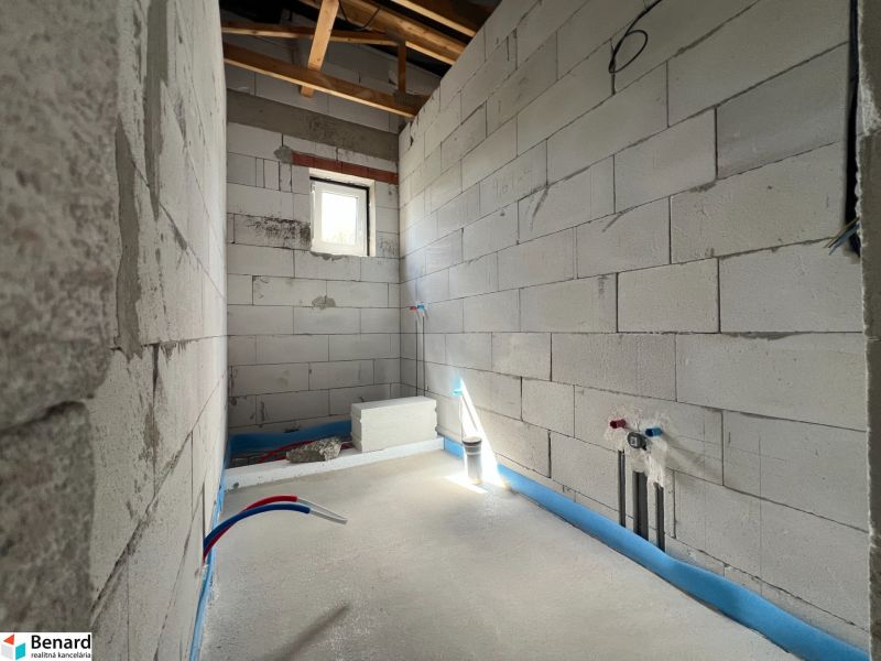 Interior construction of commercial spaces with installation wiring and a window on a white wall.