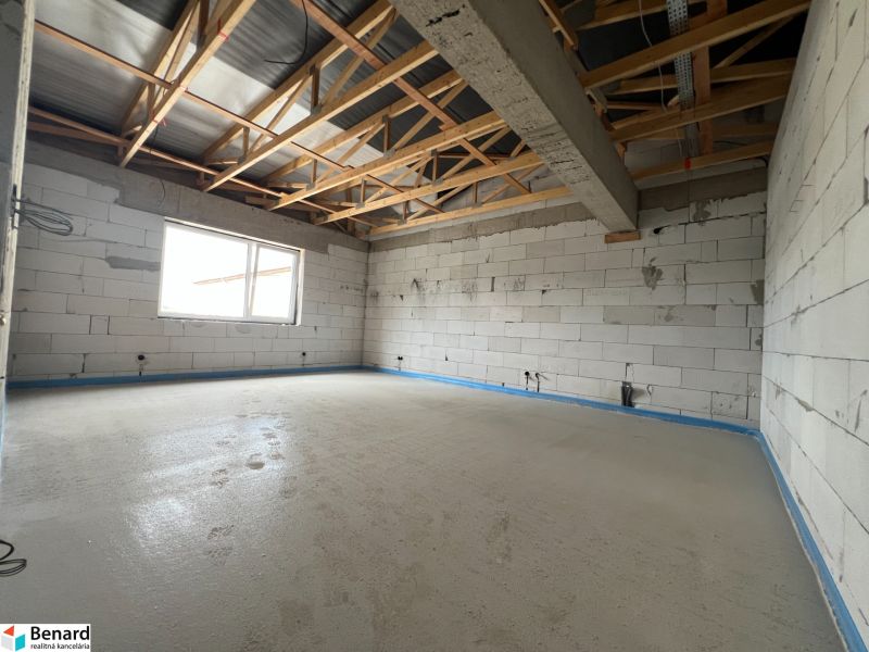 The interior of commercial premises with an unfinished floor and raw brick walls.